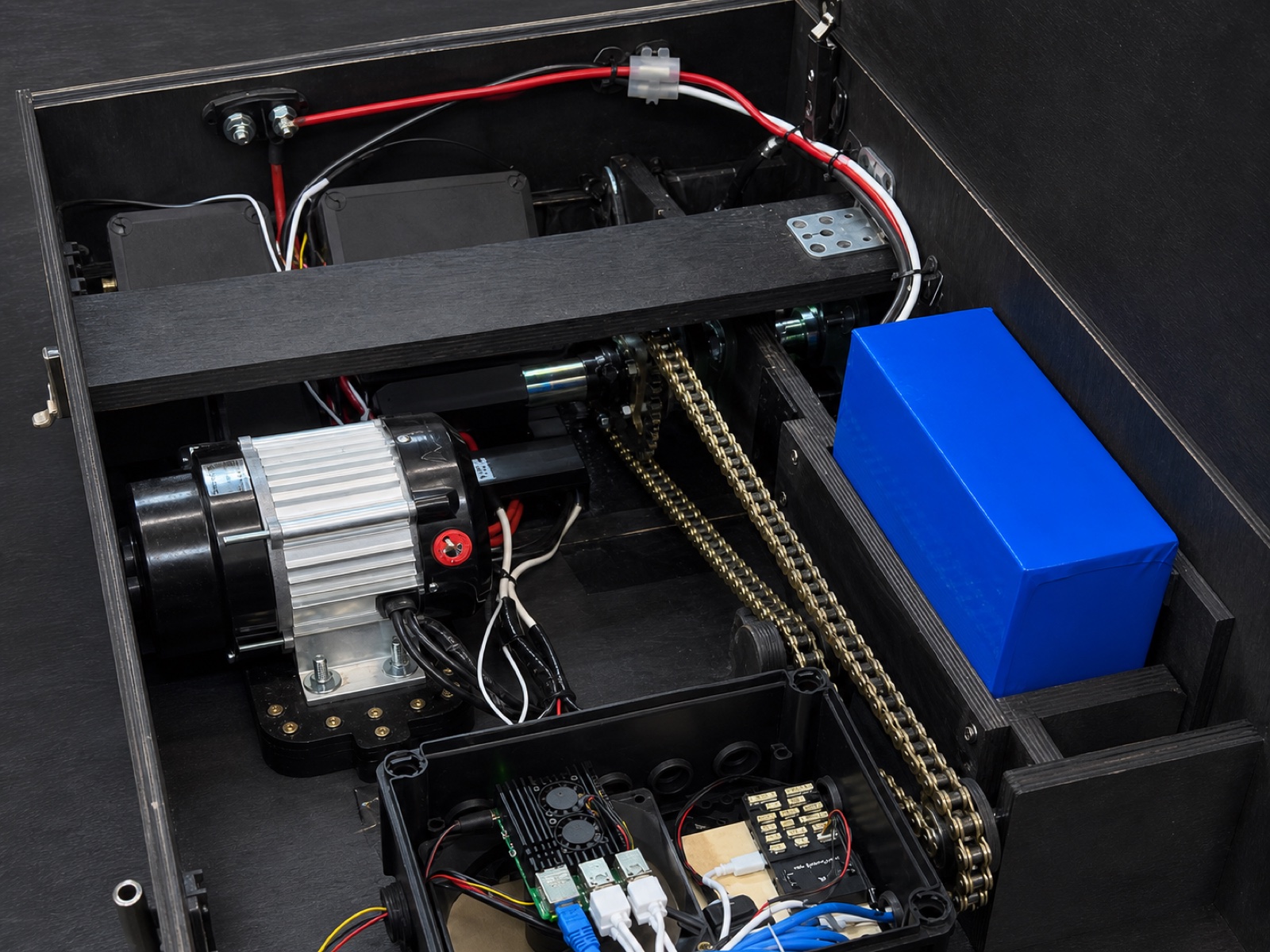 Reconstruction from a HARDY prototype photograph showing the serviceable electronics enclosure, power wiring, battery and plywood cross-rib